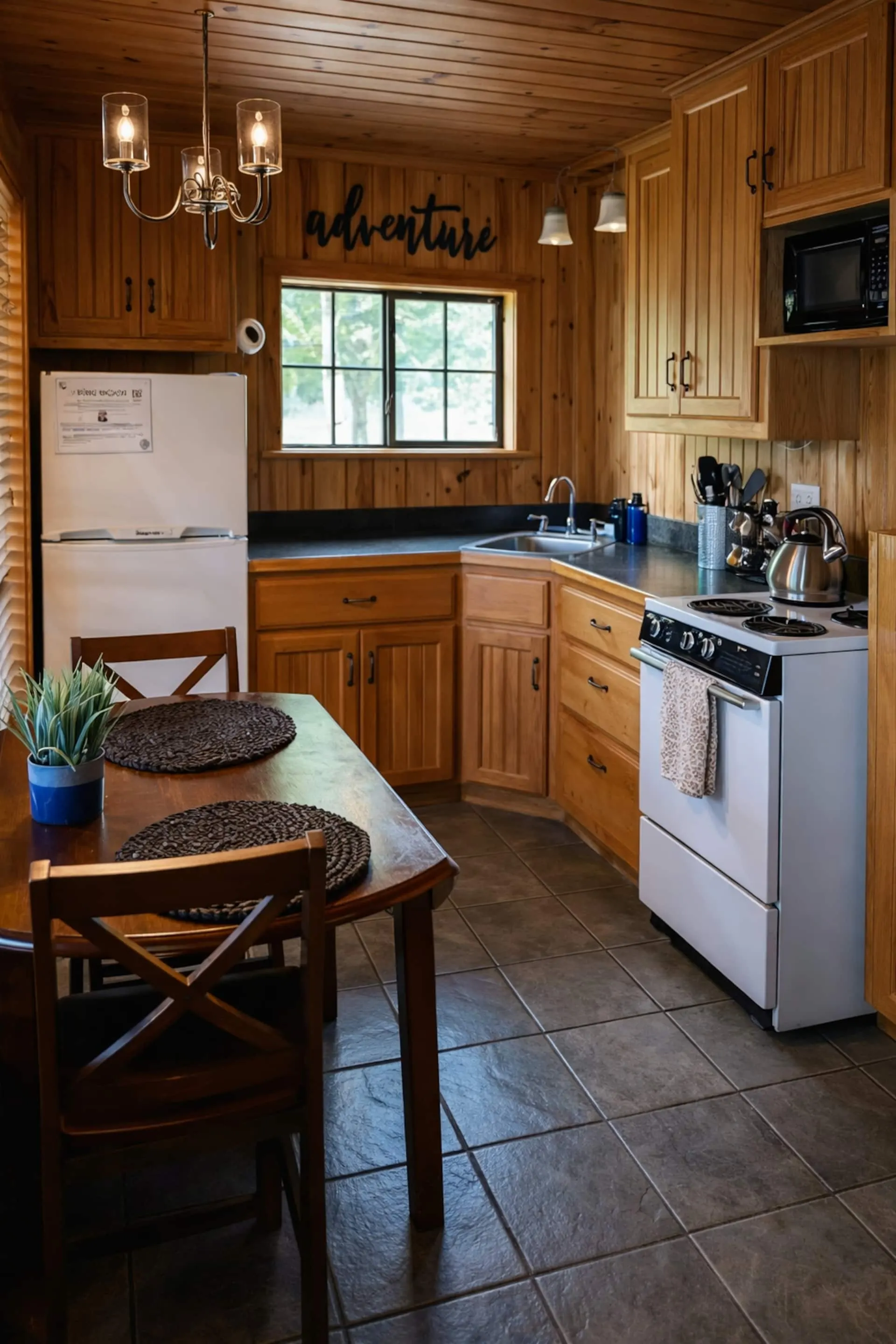 Fully equipped kitchen with wood cabinets, a full-size range and refrigerator, coffee maker and a round dining table for four